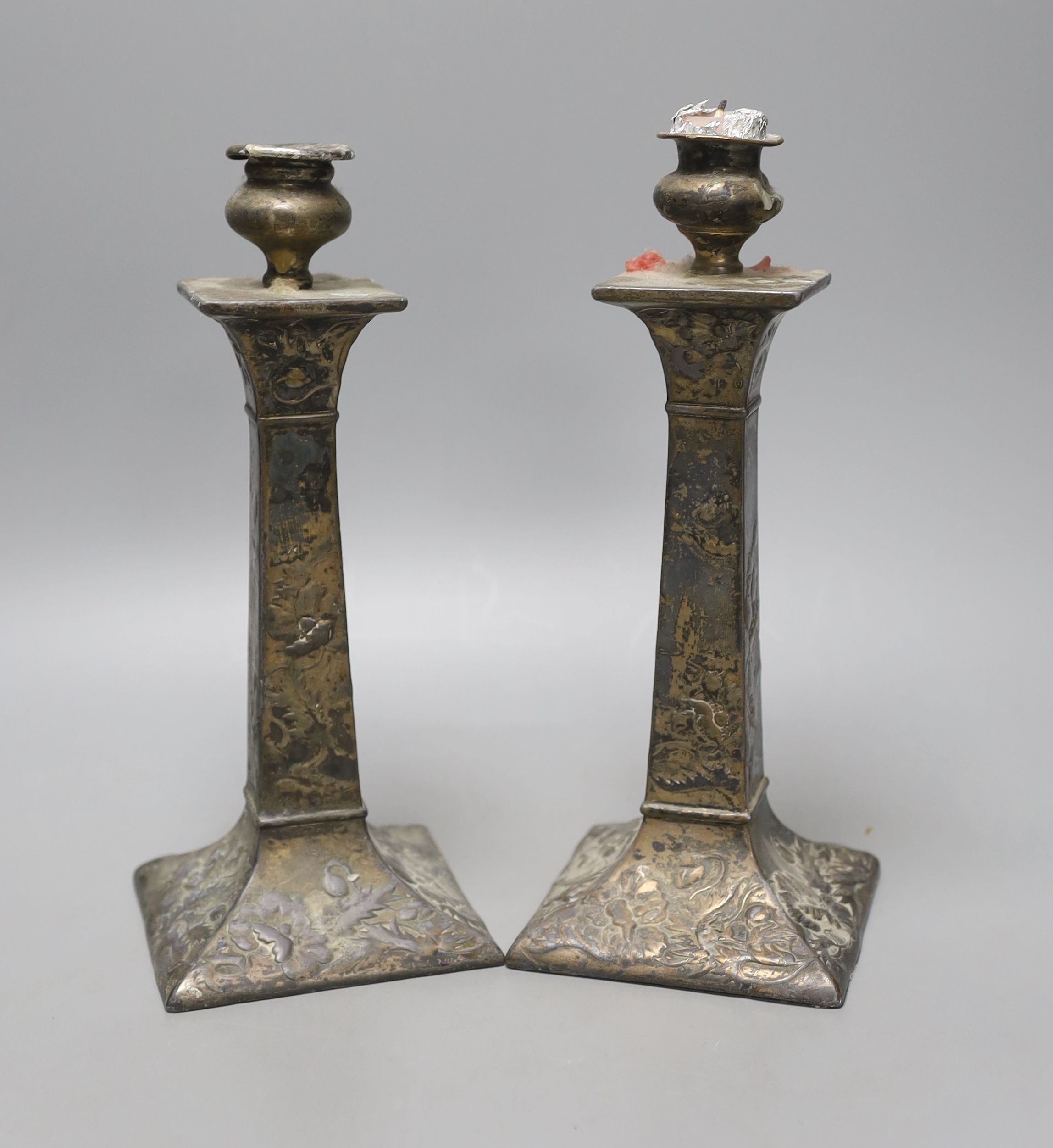 A pair of Japanese square footed embossed plated candlesticks, c.1900, 23cm tall